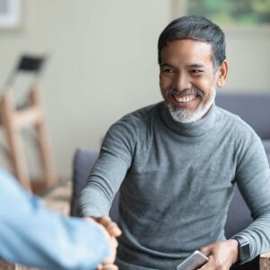 smiling man shaking hands with another man